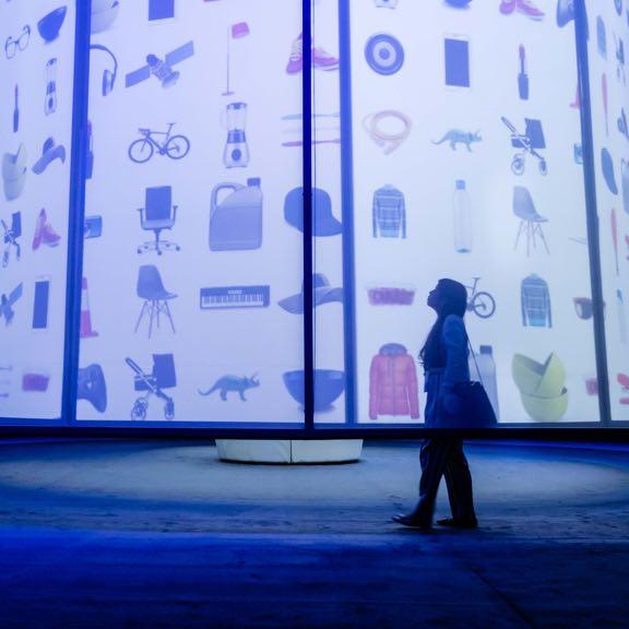 Person walking down a hallway with blue screens from a differen point of view.